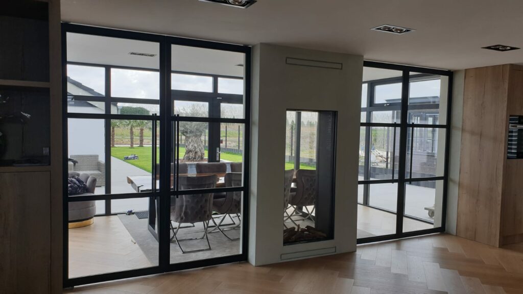 Stalen pivotdeur met glaspanelen — modern interieur